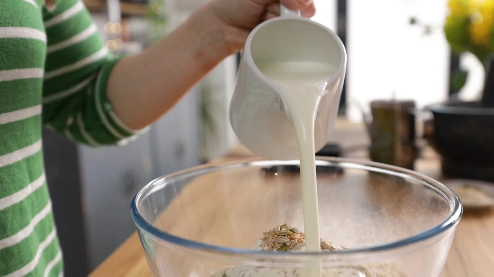 Person pouring buttermilk into mixture