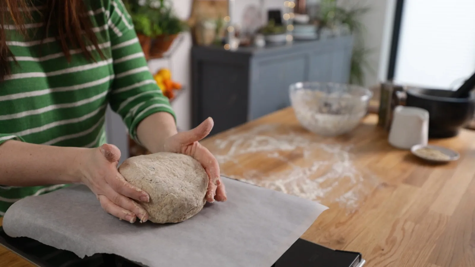 Person mixing into dough on tray