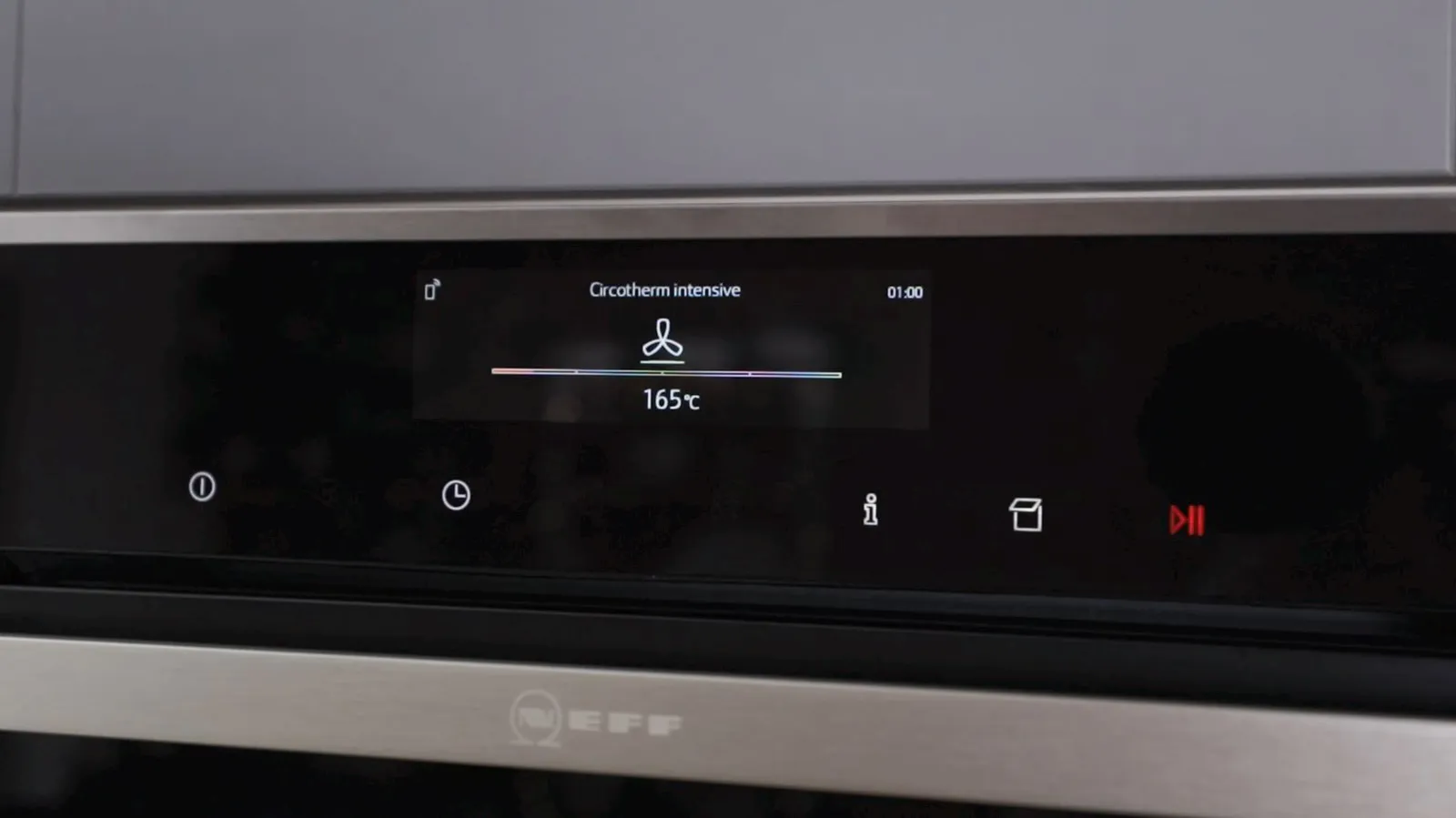 A close-up of a Neff oven's digital display showing "Circotherm intensive" mode set to 165°C with a fan icon and a timer of 01:00.