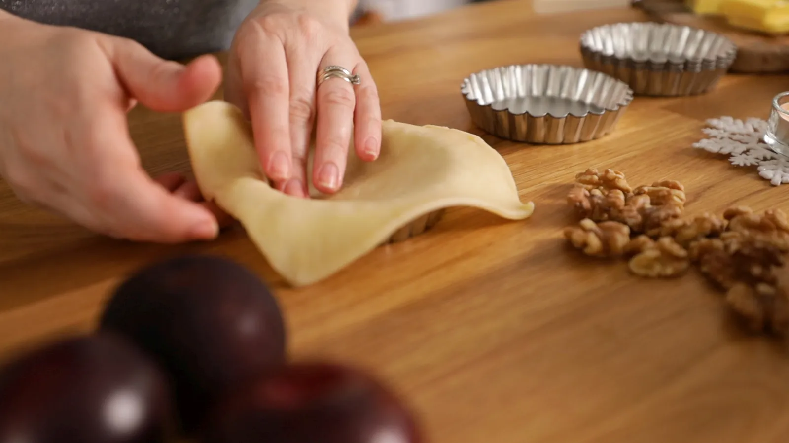 Pastry sheets being pushed into tins