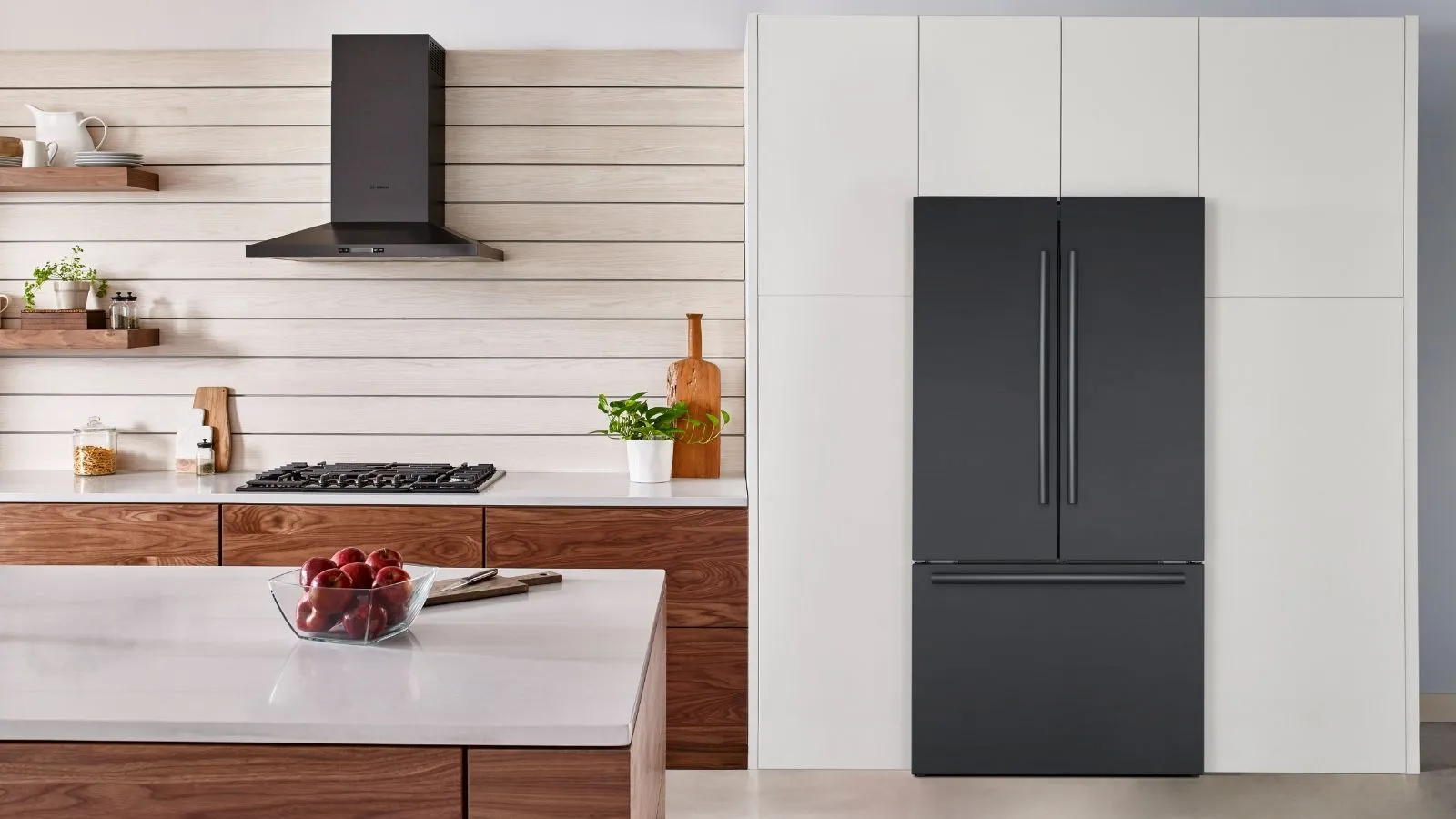 Modern kitchen with a Bosch black French door refrigerator and sleek wooden and pearly white cabinetry.