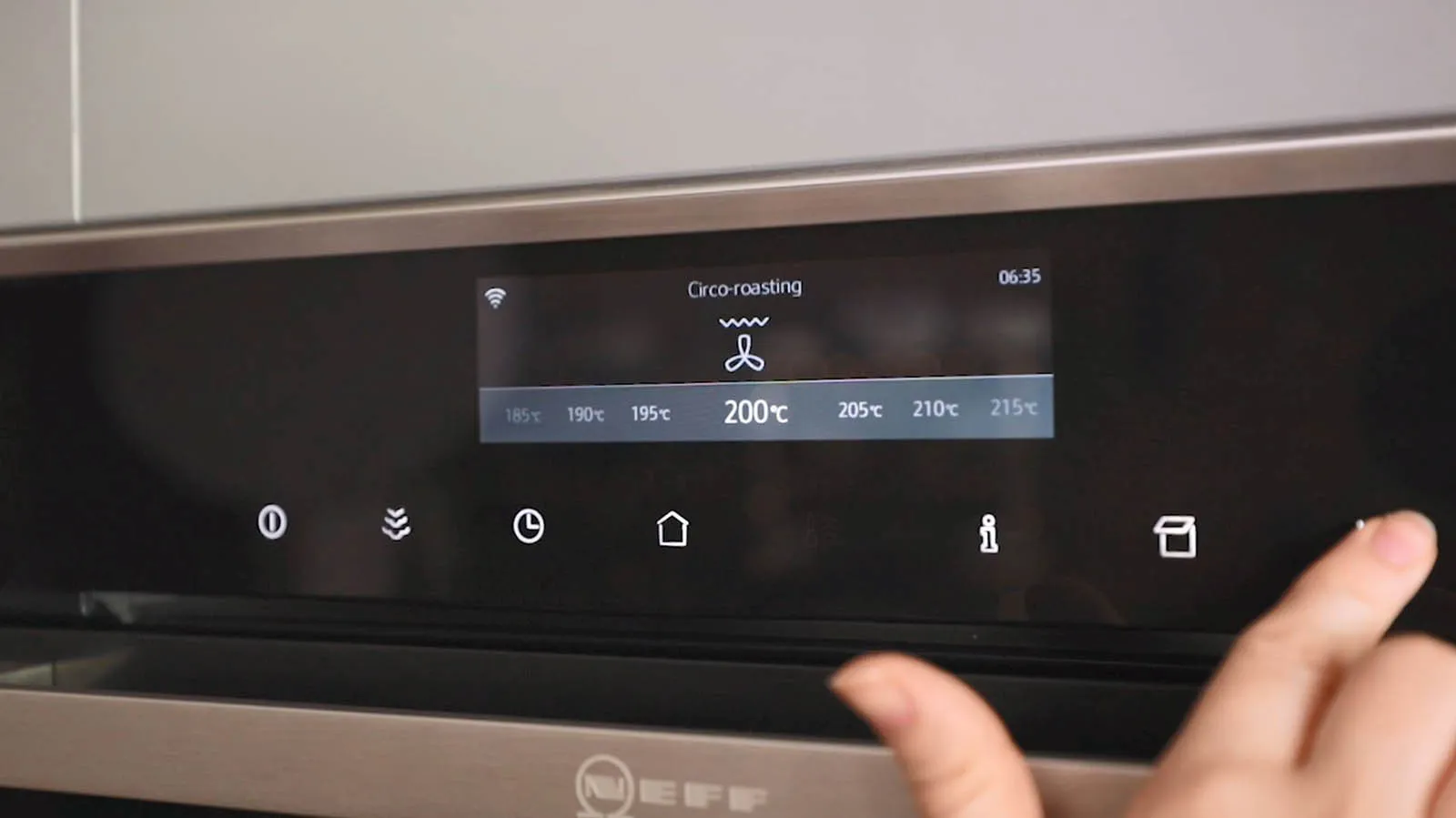 A finger taps the digital display of a Neff oven, showing "Circo-roasting" mode set to 200°C.