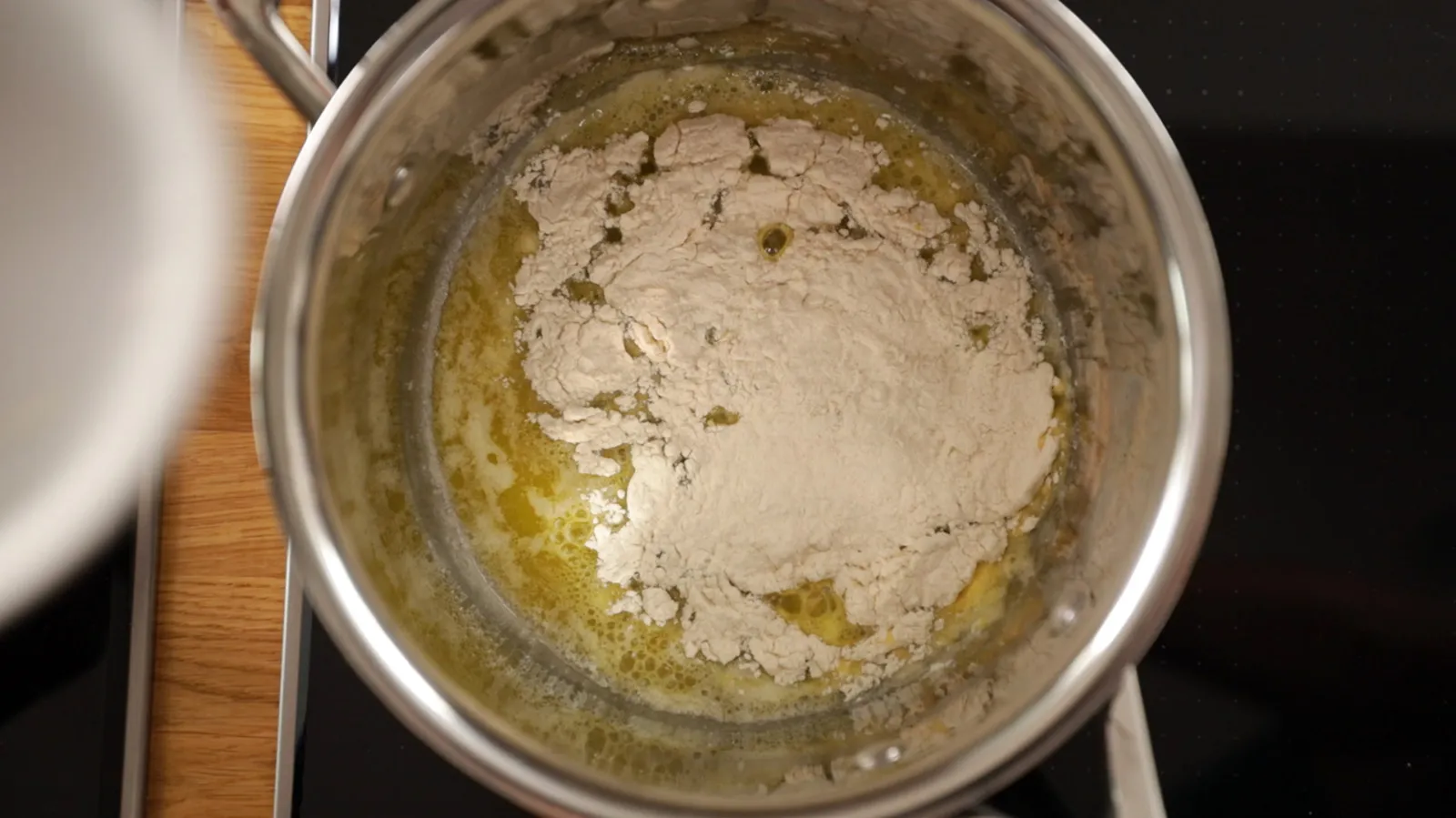 Mixing bowl with cooking utensils, and wooden surface.