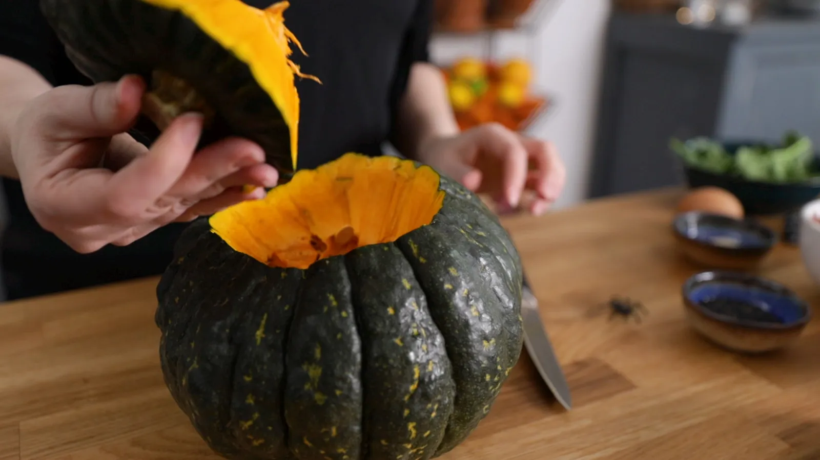 Person cutting top off of pumpkin
