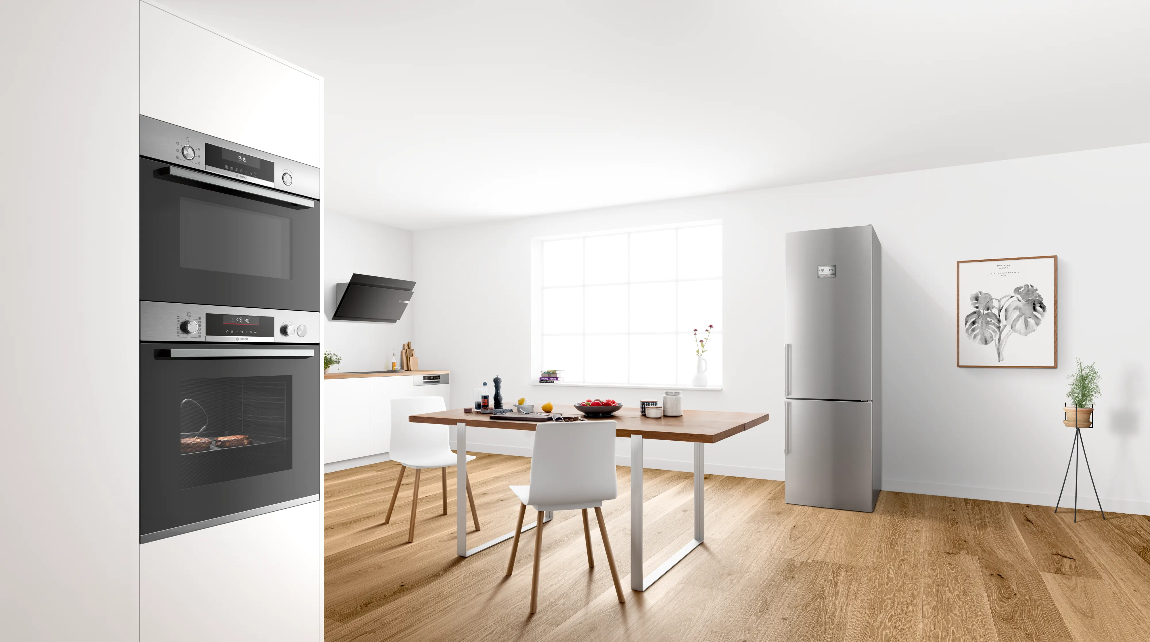 Eine minimalistische, weiße Wohnküche mit integriertem Bosch Backofen-Set, einem freistehenden Edelstahl-Kühlschrank und einem hölzernen Esstisch.