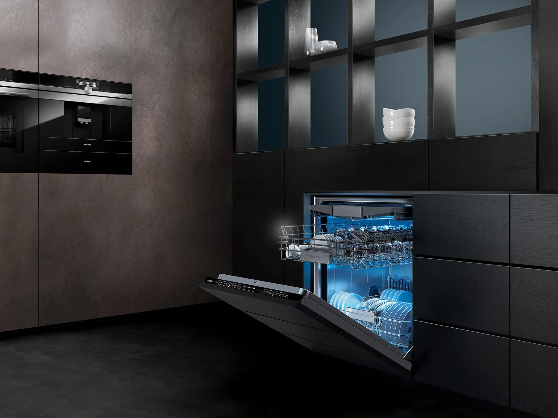 Modern kitchen with black cabinets, dishwasher, and shelving displaying decorative items.