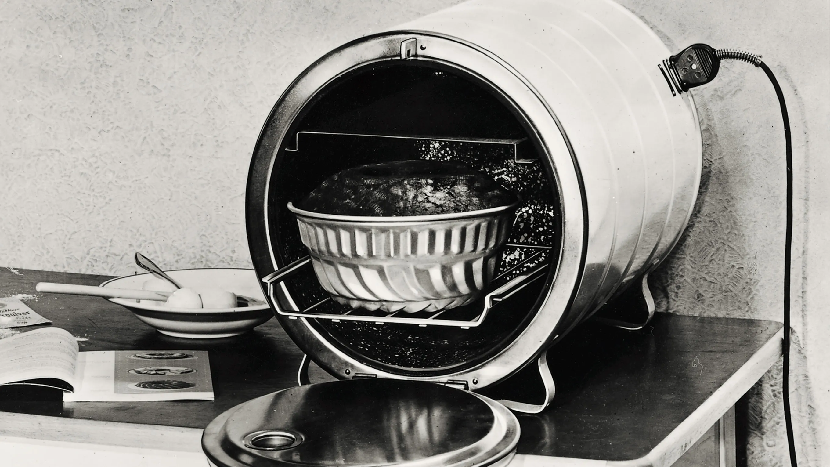 Vintage kitchen appliance, pressure cooker, cooking utensils, black and white photography.