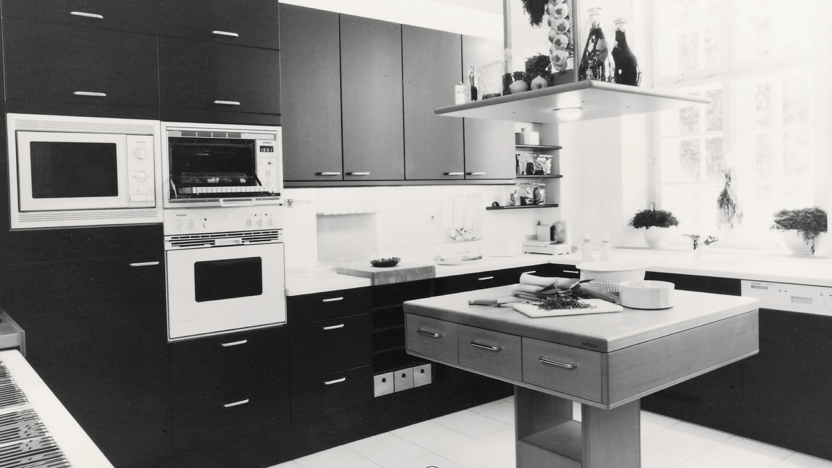 Modern kitchen with black and white cabinets, appliances, and island.