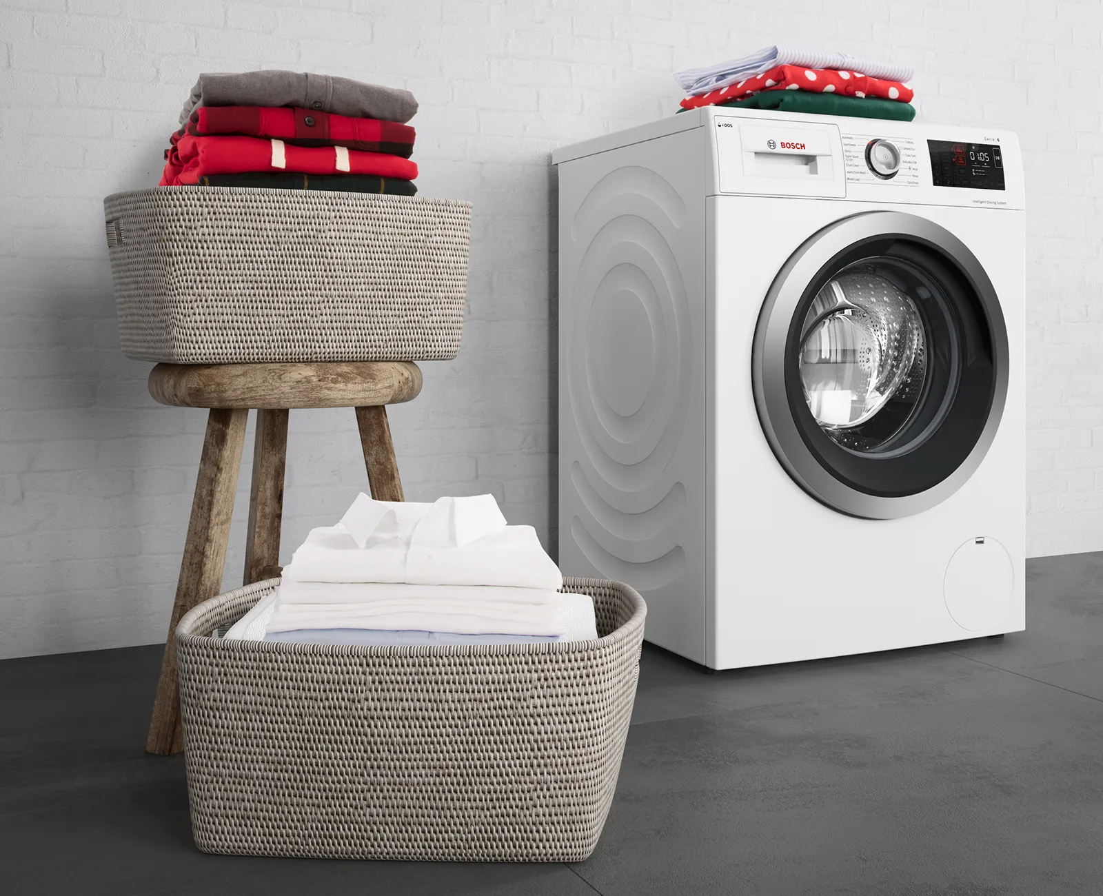 Washing machine, laundry baskets, folded towels, and a wooden stool in a minimalist laundry room setting.