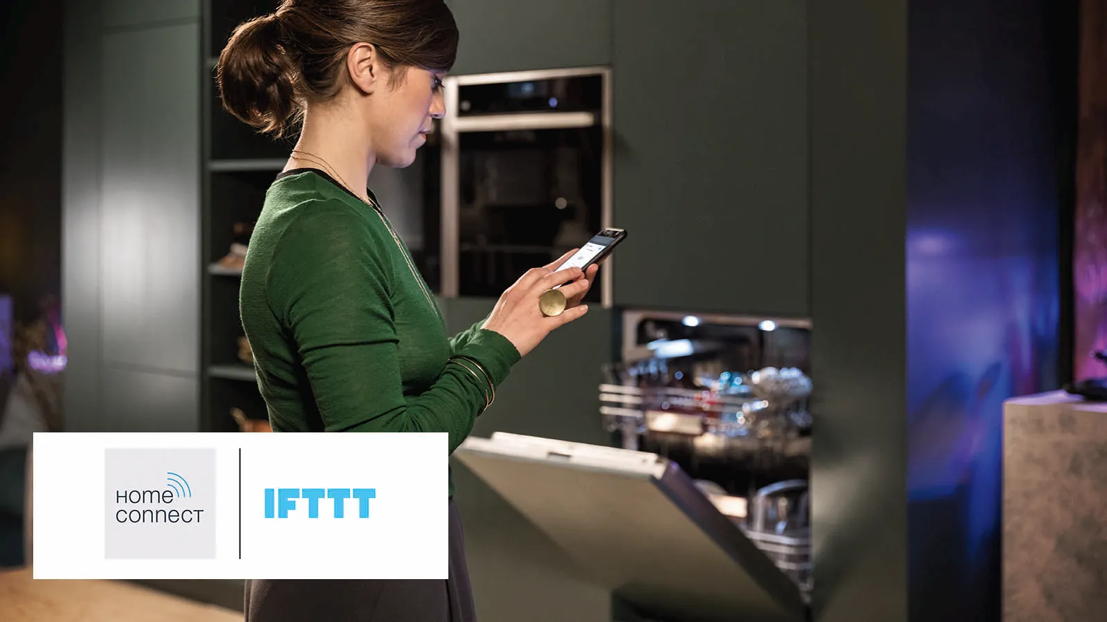 Person holding a phone with open dishwasher