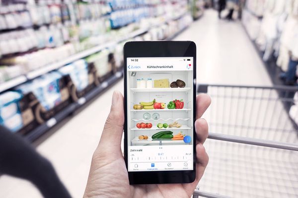 A person using the Home Connect app to look inside their fridge whilst in the supermarket