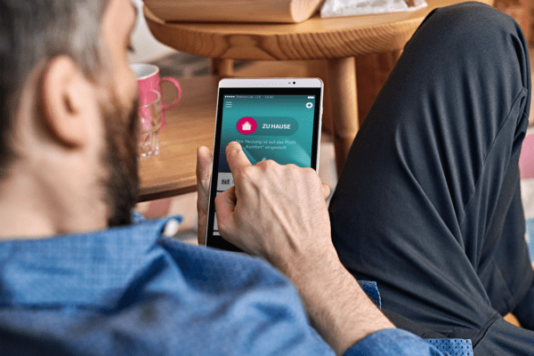 Home Connect Magenta Smart Home Mann mit einem Tablette