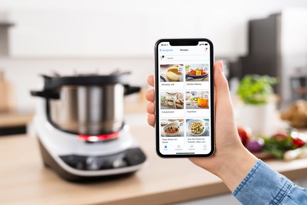 Смартфон с приложението Home Connect пред Cookit
