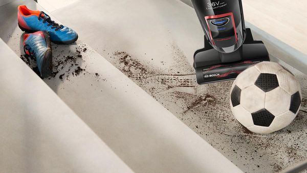 Ein Teppich wird mit einem Bosch Athlet Akku-Staubsauger gereinigt.