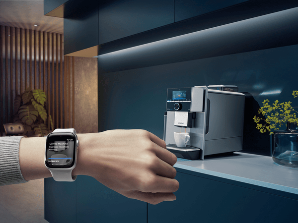 Arm med Apple Watch framför kök med kaffemaskin med Home Connect