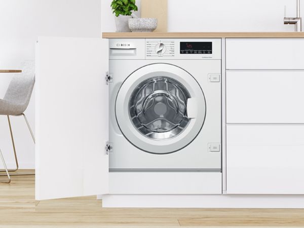 Bosch Frontlader-Einbau-Waschmaschine in einer modernen wei&szlig;en K&uuml;che