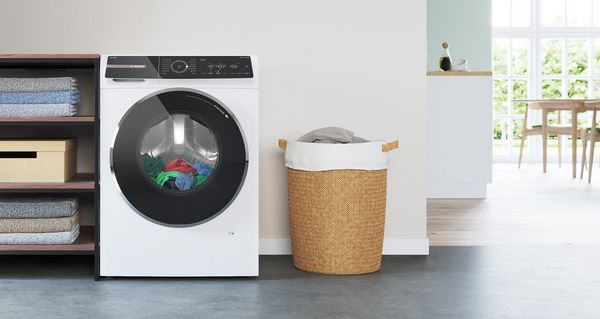 Freistehende Bosch Waschmaschine mit Trockner in einem modernen wei&szlig;en Waschraum.