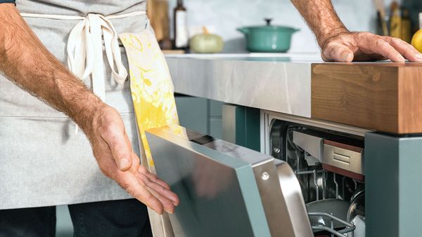 In the image detail, a man is opening a Home Connect dishwasher.