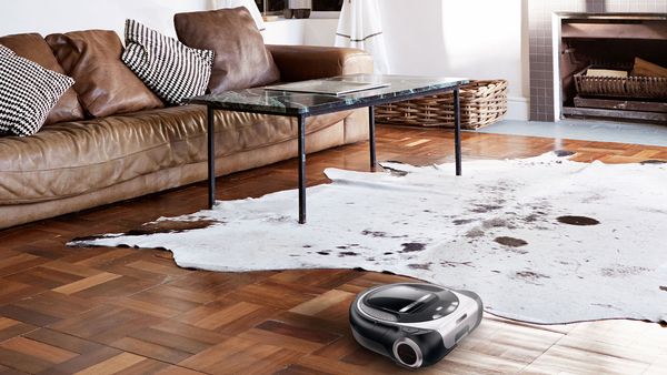A Home Connect vacuum cleaner in the middle of modern living room