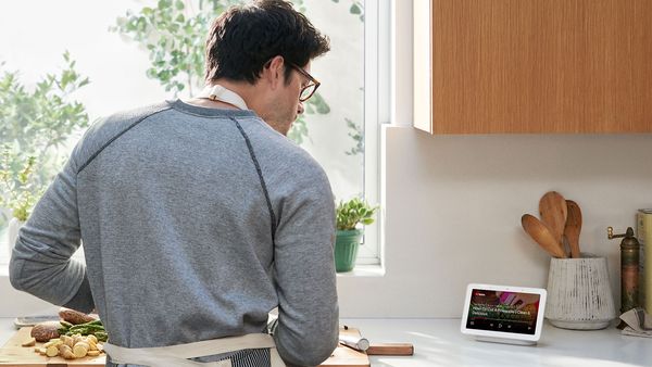 Mann in der Küche mit Google Assistant