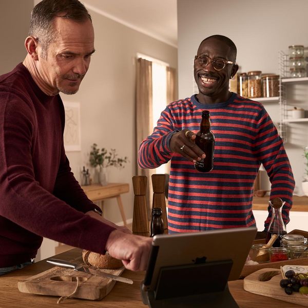 Een blij stel met een tablet in de keuken