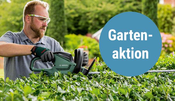 Ein Mann schneidet eine Hecke mit einer Motors&auml;ge.