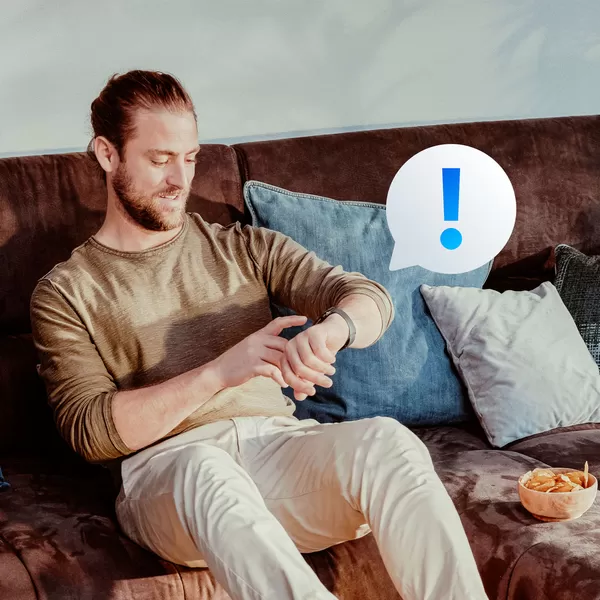 Man looking at Smartwatch on couch