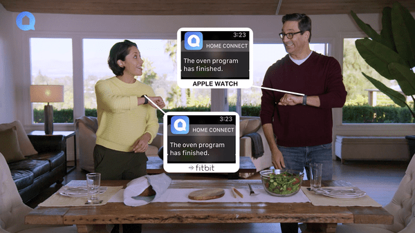 People recieving home connect notifications on their smartwatches while cooking