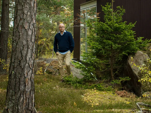 Man standing in forest surrounded by trees and rocks.