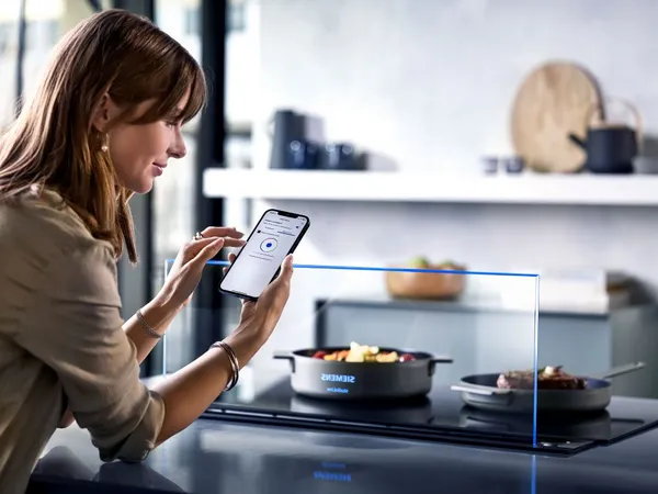 Una joven controla su electrodoméstico desde la app de Home Connect