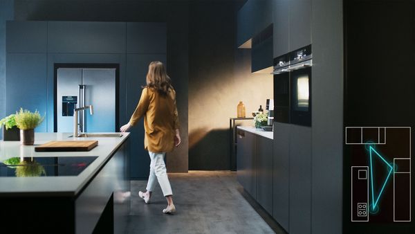 La vidéo montre la disposition optimale des appareils électroménagers avec des trajets courts dans une cuisine moderne ouverte avec îlot. 