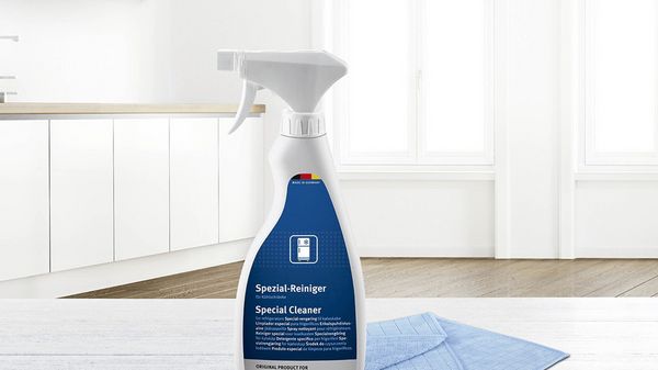 A bottle of detergent against a brightly lit room with white furniture.