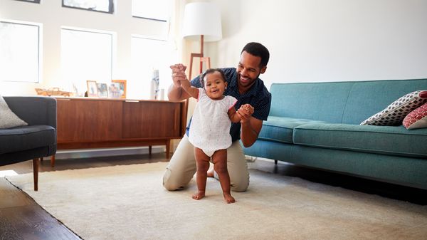 Man playing with a child in a living-room