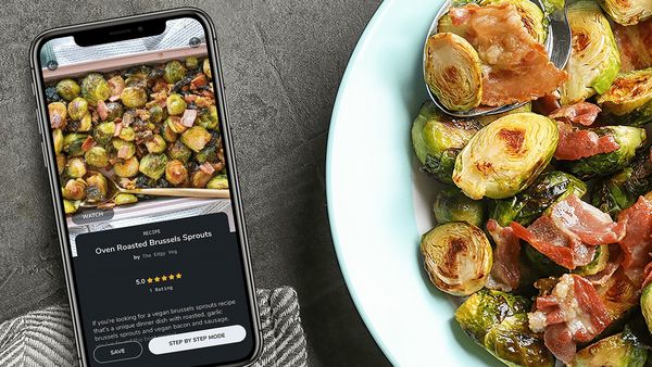 A phone and plate of brussel sprouts