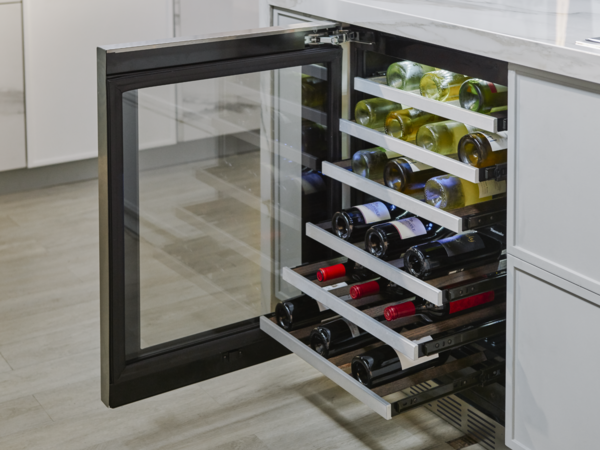 Réfrigérateur sous le comptoir ouvert et rempli de bouteilles de vin