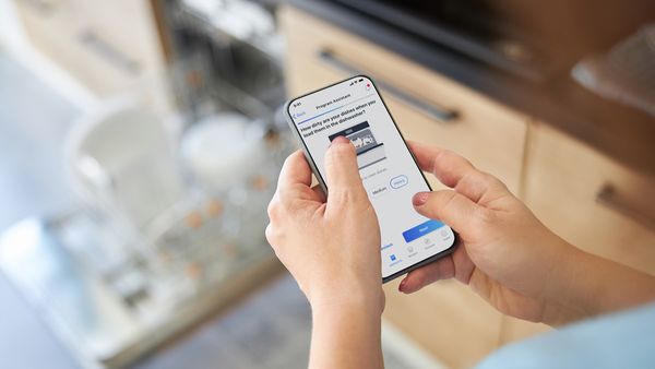In the image detail, a man is using Home Connect app with dishwasher.