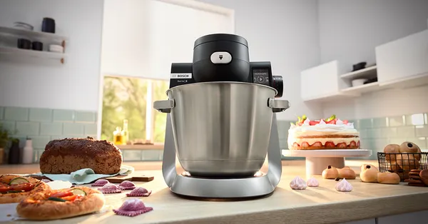 Stand mixer Series 6 on a kitchen counter top, pasta and cake next to it.