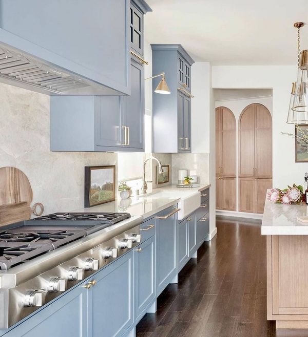 Blue kitchen with farmhouse sink and Thermador gas range top