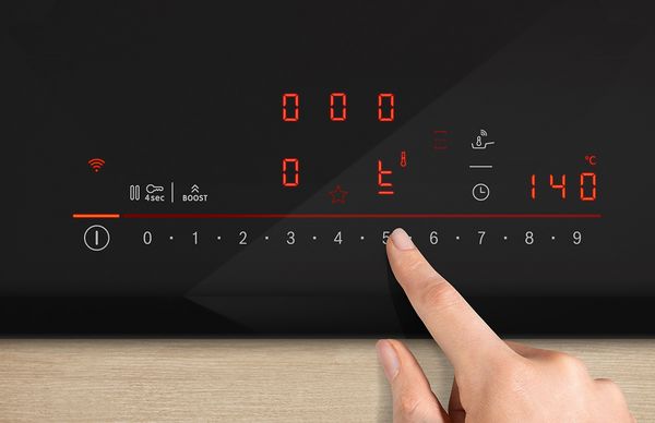 Ein Finger w&auml;hlt Einstellungen an der digitalen Schnittstelle des Induktionskochfelds.