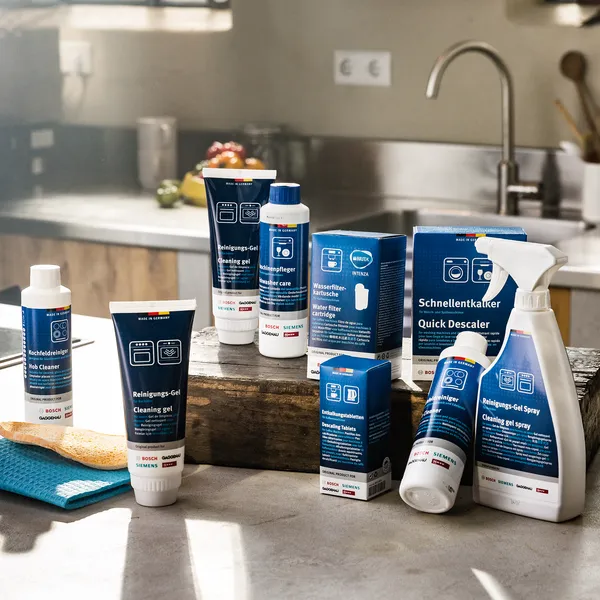 Διάφορα καθαριστικά σε μικρά μπουκαλάκια πάνω στον πάγκο κουζίνας