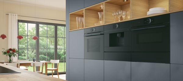 Ein Bosch Hei&szlig;luft Backofen im Vordergrund in einem hellen modernen Esszimmer.