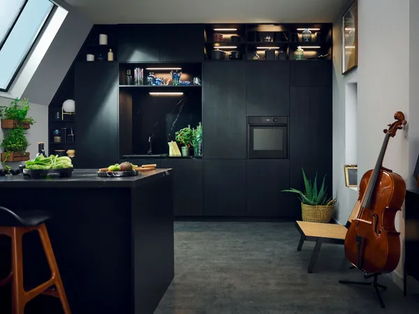 Moderne schwarze Küche mit Musikinstrumenten, Pflanzen und minimalistischem Dekor.