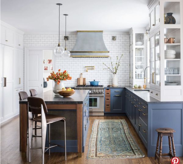 Blue kitchen with island and glass cabinets.