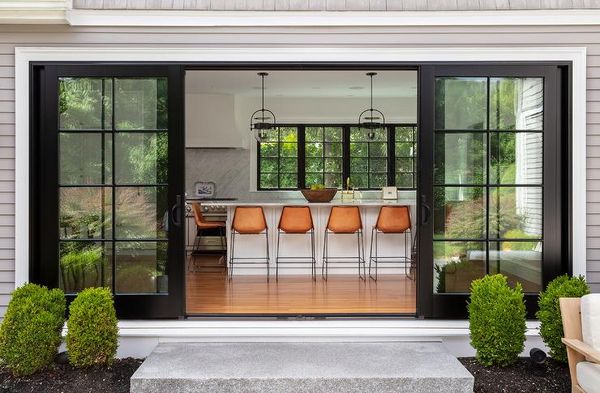 Tabourets orange dans une cuisine avec portes-patio coulissantes avec cadre noir