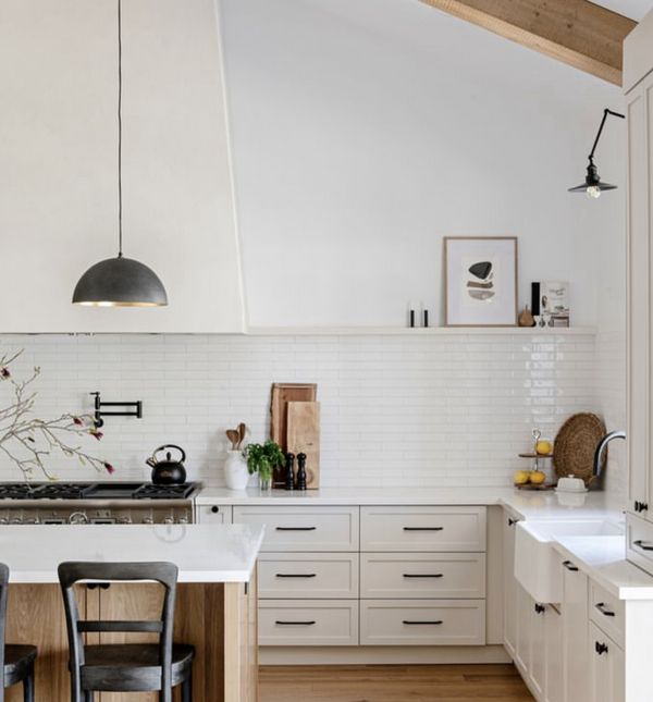 Narrow shelf above tile backsplash in white kitchen with beams