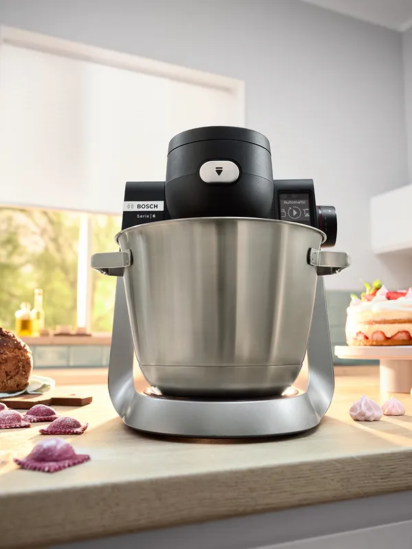 Stand mixer Series 6 on a kitchen counter top, pasta and cake next to it.