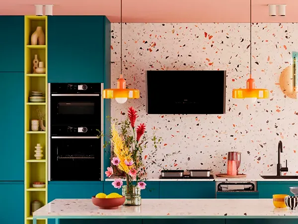 Bunte moderne Küche mit Terrazzo-Arbeitsplatte, eingebauten Geräten und lebendigem Blumenarrangement.