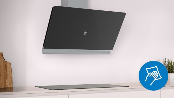 Campana extractora de pared de color negro con icono de paño, comunicando fácil limpieza