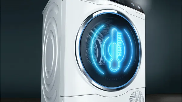 Futurystyczna pralka ze świecącą niebieską ikoną na wyświetlaczu, reprezentująca zaawansowaną technologię.