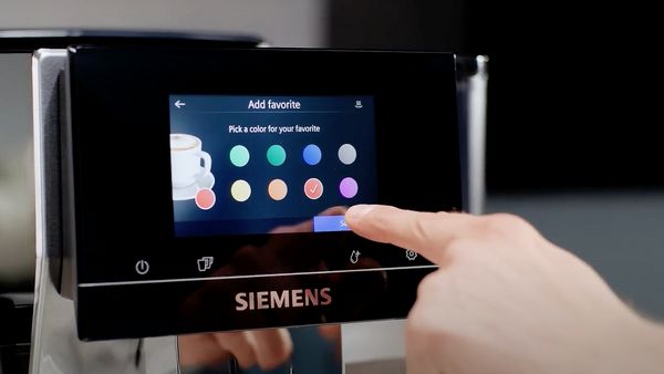 Un doigt effleurant l'écran tactile d'une machine à café Siemens, dans la section « Ajouter un favori » du menu sur l'écran.